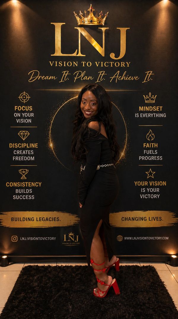 Woman in black dress posing confidently in front of a motivational LNJ Vision to Victory backdrop.