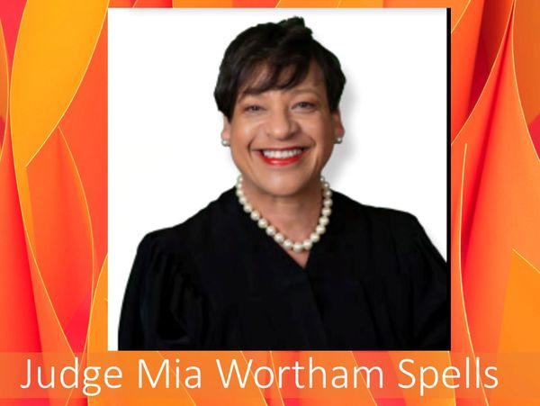 Judge Mia Wortham Spells smiling in a black robe and pearl necklace.