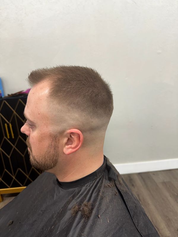 Man with a fresh, clean fade haircut and trimmed beard.