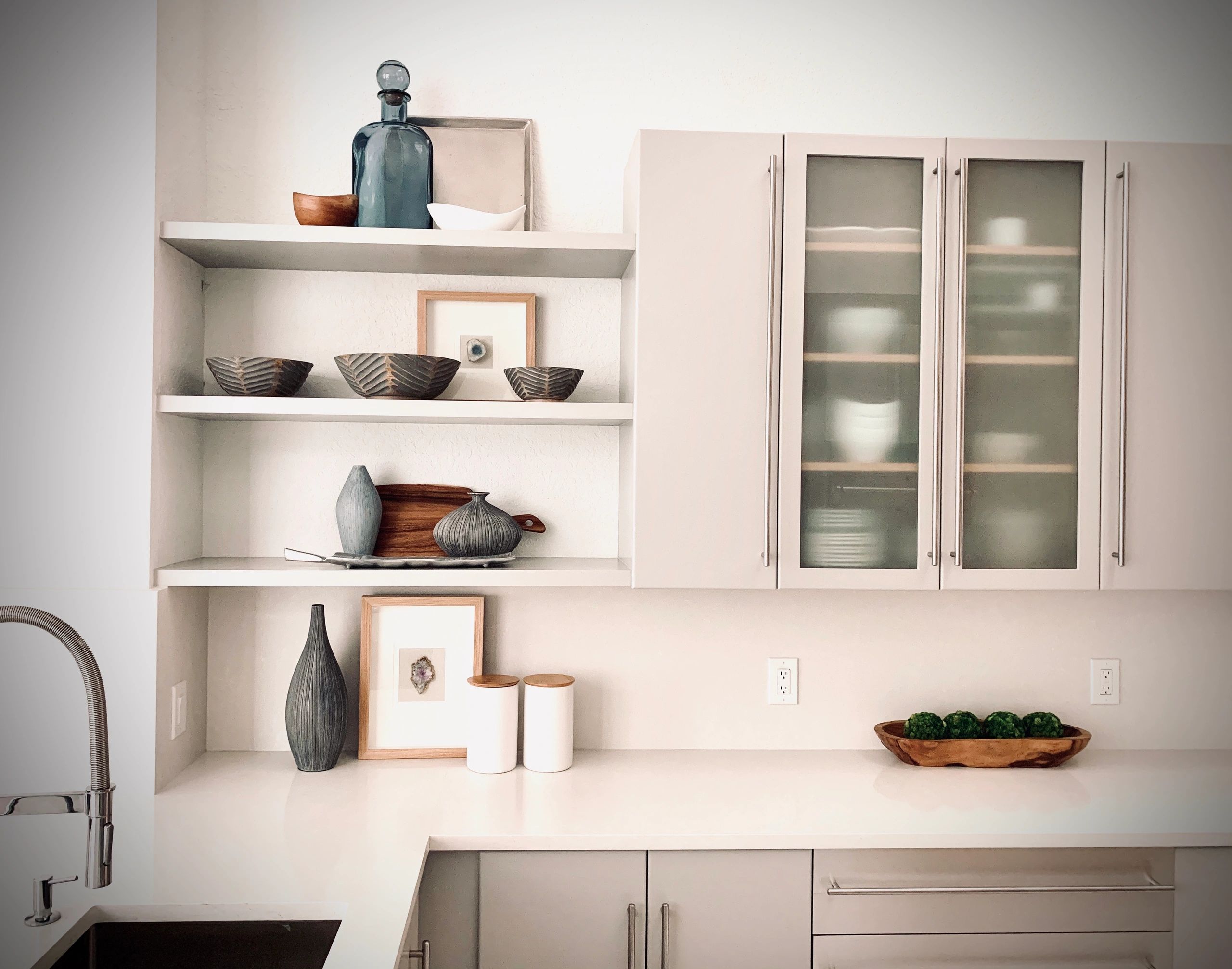 Modern natural kitchen design with chrome faucet, wood accents, white walls and greige, gray, beige 