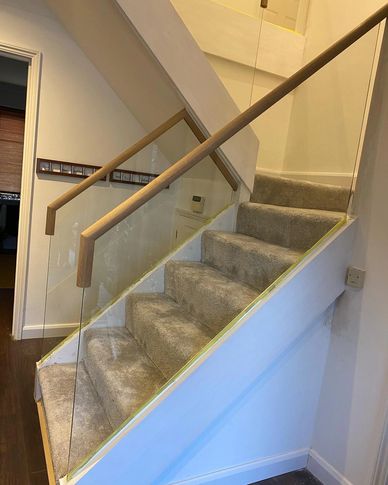 White with Oak mop stick handrails and frameless glass installed in Kings Langley,  Hertfordshire.