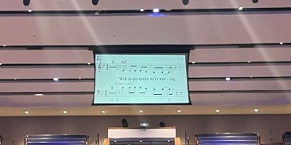 Projection screen displaying musical notes in a concert hall.