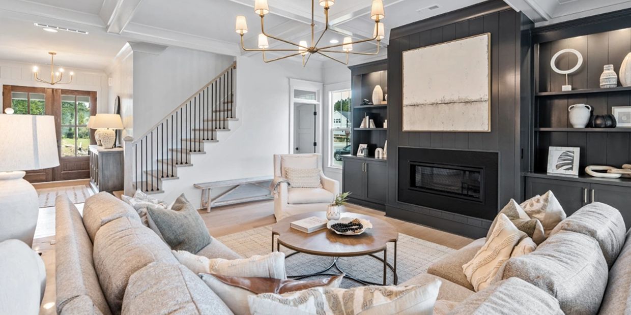 Modern living room with neutral tones, a fireplace, and elegant lighting.