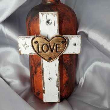 Customized orange distressed soap dispenser with a white wooden cross & love heart embellishment.