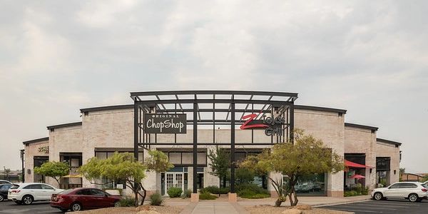 Exterior of a commercial building with signage for Original ChopShop and ZZ Tejas Grill.
