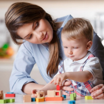 Mother and child playing with wooden blocks together.
