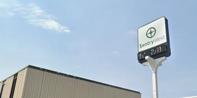 SentryWest security company sign against a blue sky.