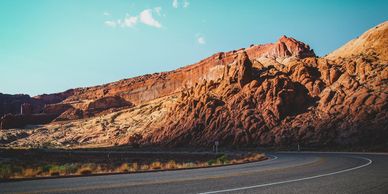 A winding road in a red rock desert landscape.