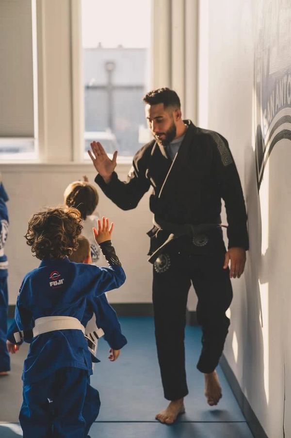 Prof. Platt giving high five after Kids BJJ Gi Class