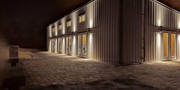 Modern building with warm lights glowing at night.