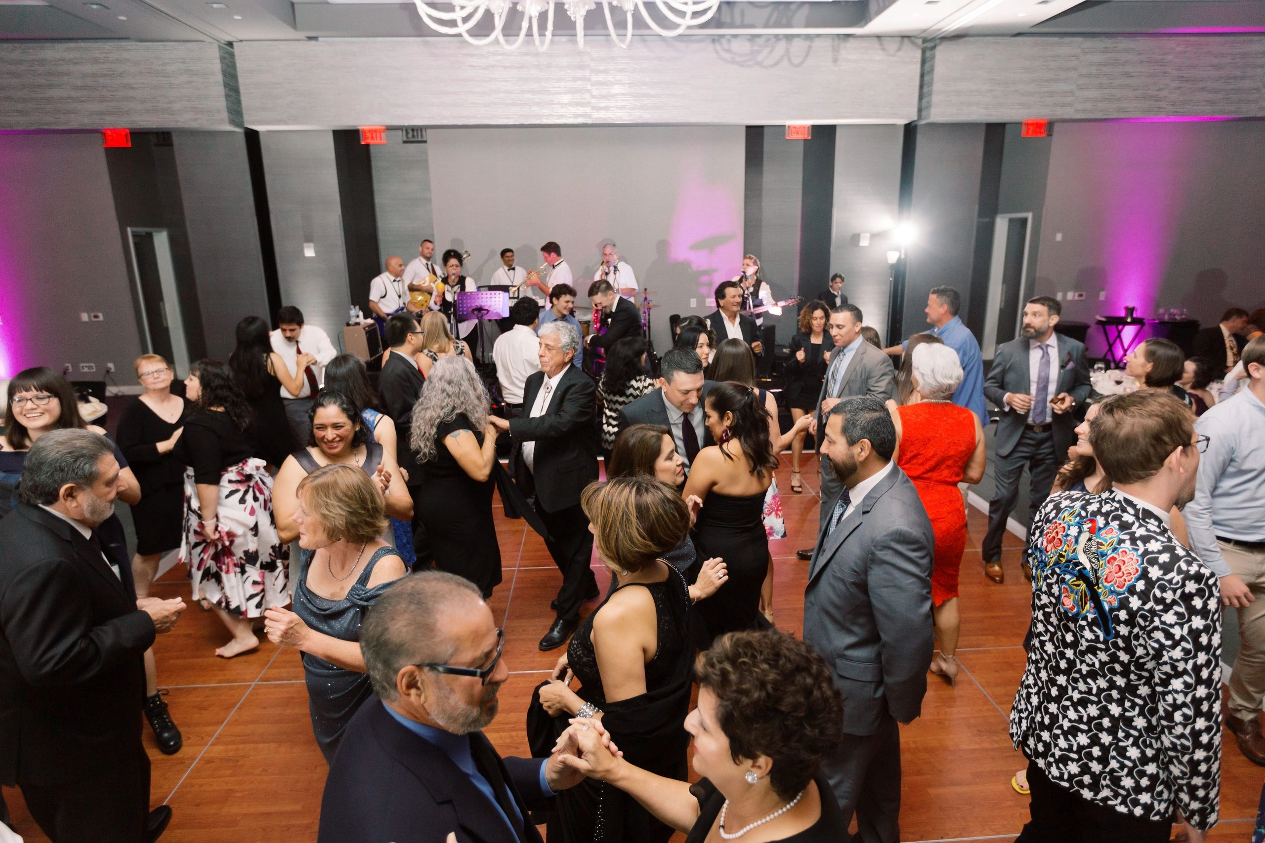 Guests dancing and enjoying live band music at a formal event.