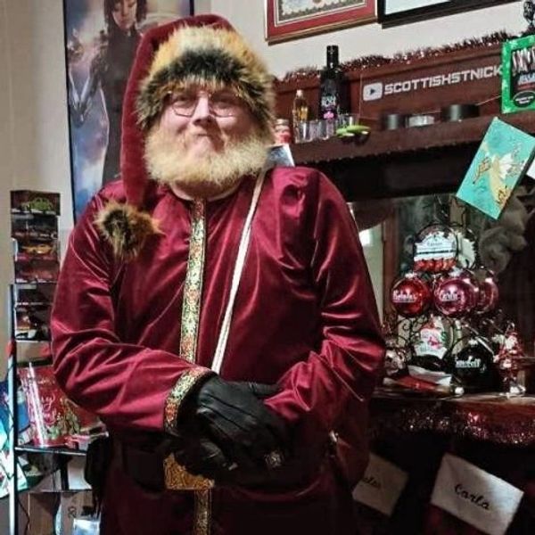 Man dressed as Santa Claus in a festive room.