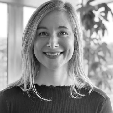 Black and white portrait of a smiling woman with light hair.
