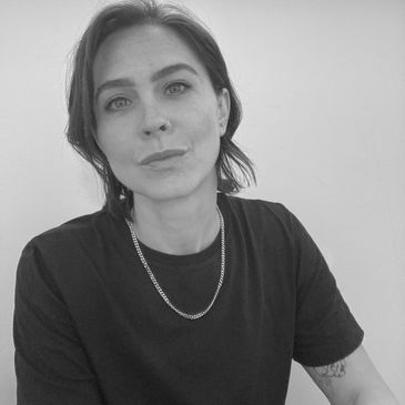 Black and white portrait of a woman with short hair and a chain necklace.