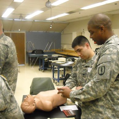 Soldiers training with a medical dummy.