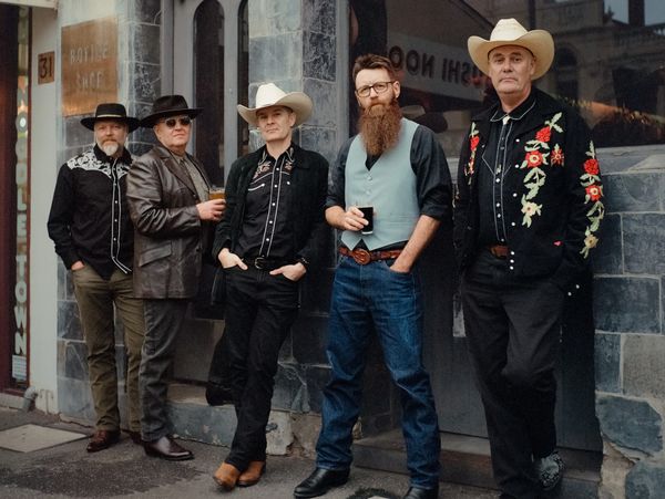 The Pourshots Country Band standing outside The Town Hall Hotel in North Melbourne. The band are wea