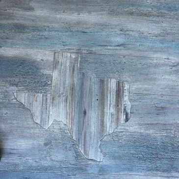 A custom concrete overlay on a porch, including a cross-grain custom logo in the shape of Texas.