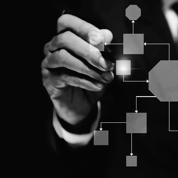 Businessman drawing a digital flowchart with various shapes and arrows.