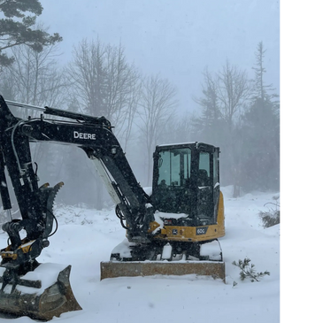 A John Deere excavator in snowy winter conditions.