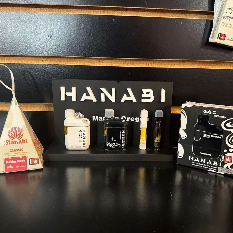 Display of Hanabi cannabis products including vape cartridges and flower packaging.