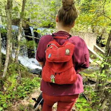 Shirley Bong standing in front of waterfall showcasing products from behind.  