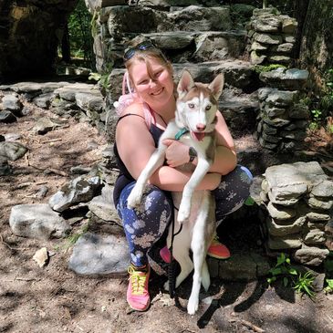 Shirley Bong and her dog Pepper sitting on castle stairs. 
