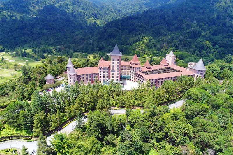 Castle-like building surrounded by lush green forest.