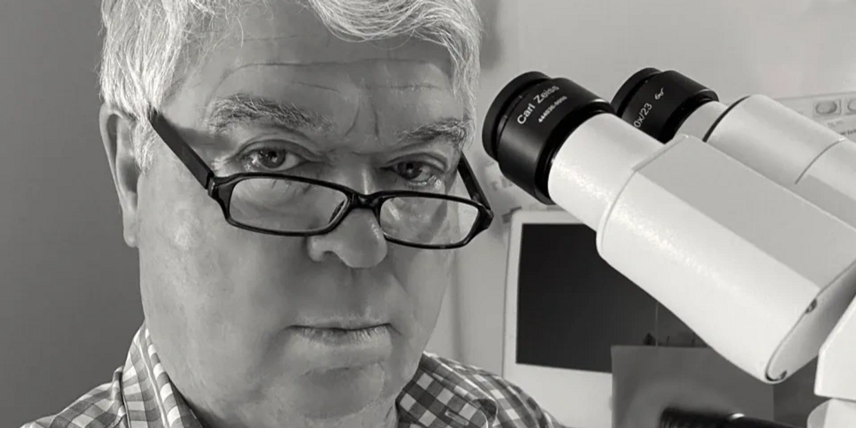 Dr. William R. Anderson MD microscope headshot.