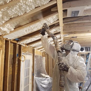 Technician applying open cell spray foam