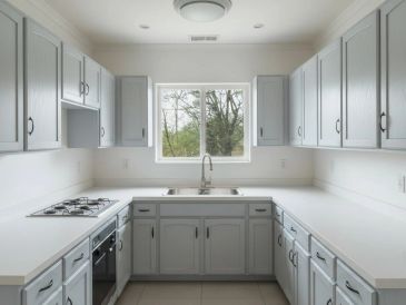 Bright kitchen with light gray cabinets and a window view.