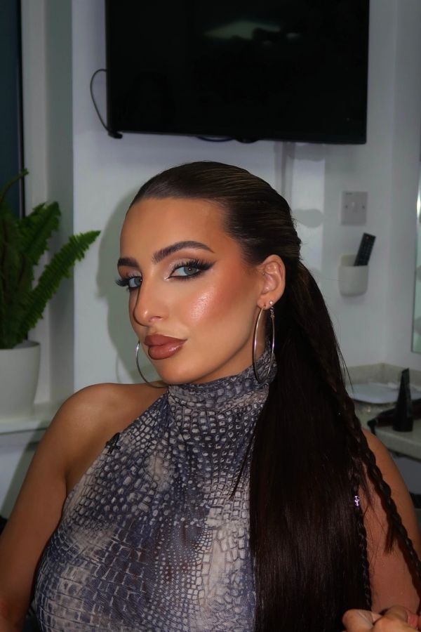 Woman with sleek long hair and hoop earrings.