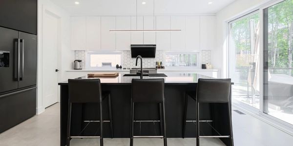 Modern kitchen with black and white contrast and large window.