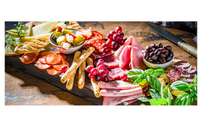 Elegant charcuterie board with meats, cheeses, grapes, olives, and breadsticks.