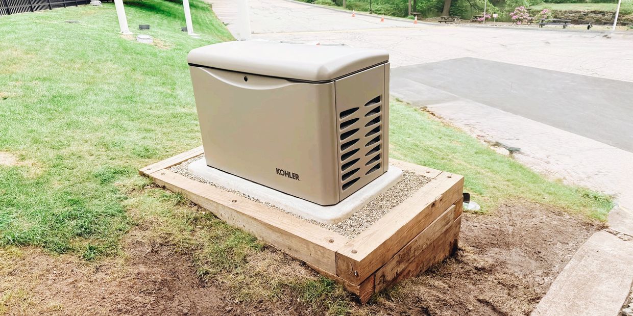 A Kohler standby generator installed on a wooden platform outdoors.