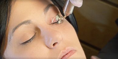 Close-up of a woman receiving eyelash extension treatment.