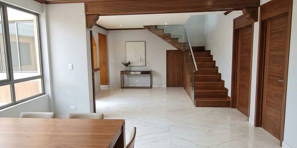 Sala moderna con escaleras de madera y piso blanco.