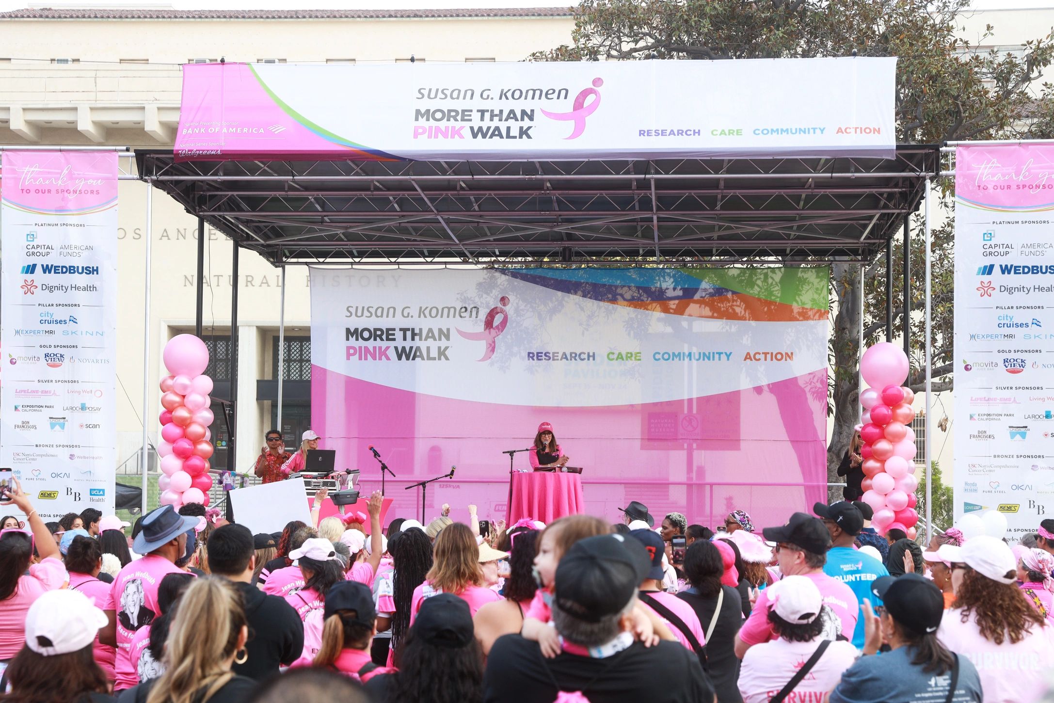 Crowd at Susan G. Komen More Than Pink Walk event with speakers on stage.