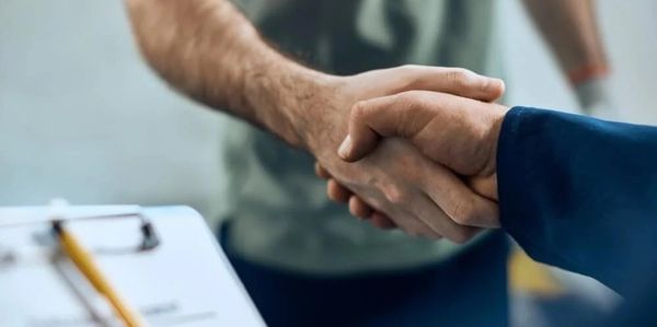 Close-up of a handshake between two people in a professional setting.