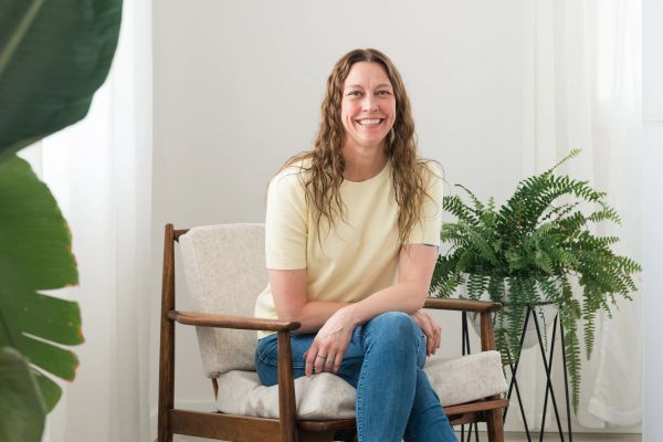 Smiling woman sitting on a chair indoors.