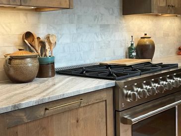Modern kitchen countertop with stove and utensils.