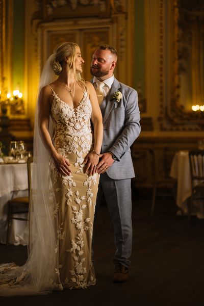 Bride and groom share a loving moment in an elegant setting.