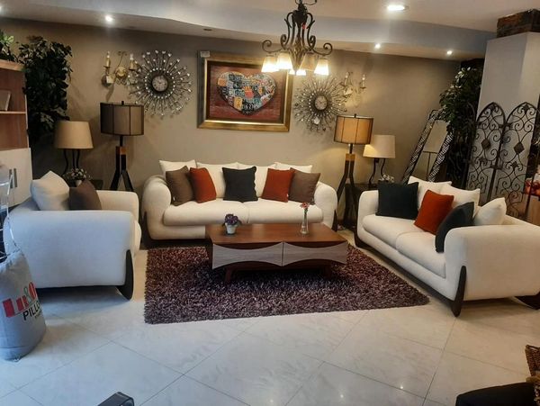 Elegant living room with white sofas, colorful cushions, and warm lighting.