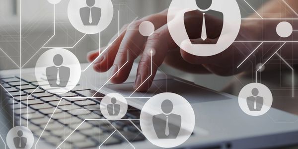 Hand typing on laptop with digital social network icons overlay.