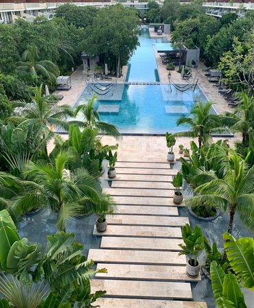 Lush tropical garden pathway surrounded by greenery at AWA Playacar, creating a peaceful resort atmo