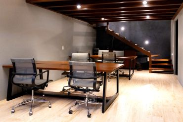 Modern office space with wooden tables and ergonomic chairs.