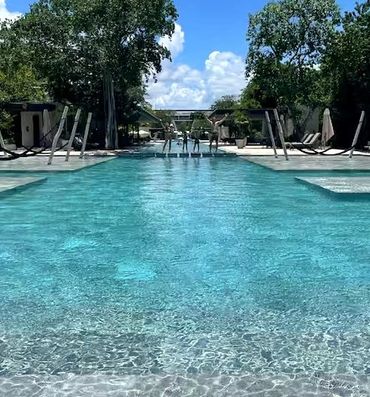 Spacious resort pool deck with lounge seating at AWA Playacar, perfect for sunbathing and unwinding 