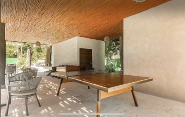 Covered outdoor game area with ping pong and foosball tables.