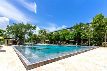 Spacious main resort swimming pool at AWA Playacar with ample lounging areas and tropical landscapin