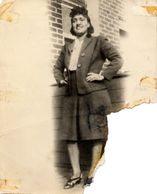 Vintage photo of a smiling woman in formal attire.