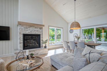 Salon moderne avec cheminée et grande fenêtre.